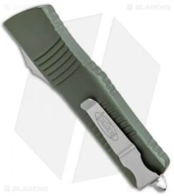 Microtech Combat Troodon OTF Knife D/E Dagger OD Green (3.8" SW Full Serr) 8 Microtech Combat Troodon OTF Knife D/E Dagger OD Green (3.8" SW Full Serr) -Blade HQ Shop Microtech Combat Troodon OTF DE Dagger OD Green SW Full Serr 142 12OD BHQ 98064 jr side